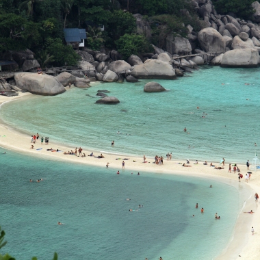 Águas azul piscina são separadas por estreitas faixas de areia branca.